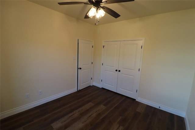 unfurnished bedroom with dark hardwood / wood-style flooring, a closet, and ceiling fan