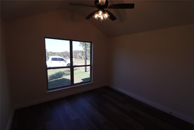 spare room featuring dark hardwood / wood-style floors, ceiling fan, and vaulted ceiling