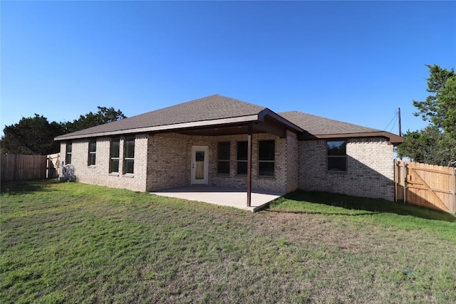 rear view of property featuring a patio area and a yard