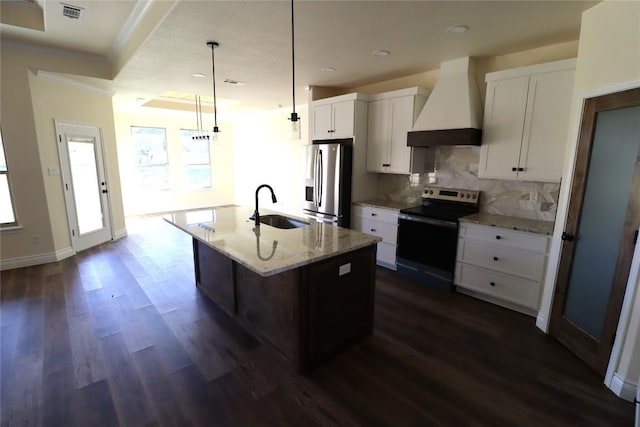 kitchen featuring sink, hanging light fixtures, a center island with sink, custom range hood, and appliances with stainless steel finishes