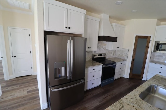 kitchen featuring white cabinets, appliances with stainless steel finishes, premium range hood, and dark wood-type flooring