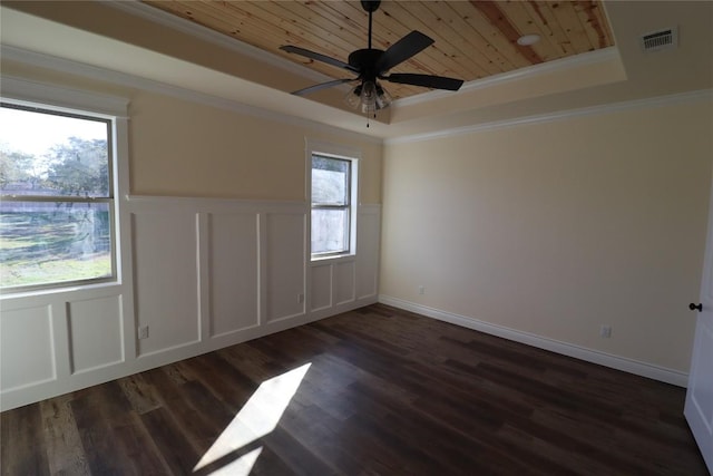 unfurnished room featuring plenty of natural light, dark hardwood / wood-style floors, a raised ceiling, and ceiling fan