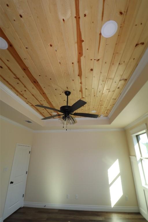 room details featuring ornamental molding, a raised ceiling, ceiling fan, hardwood / wood-style flooring, and wooden ceiling