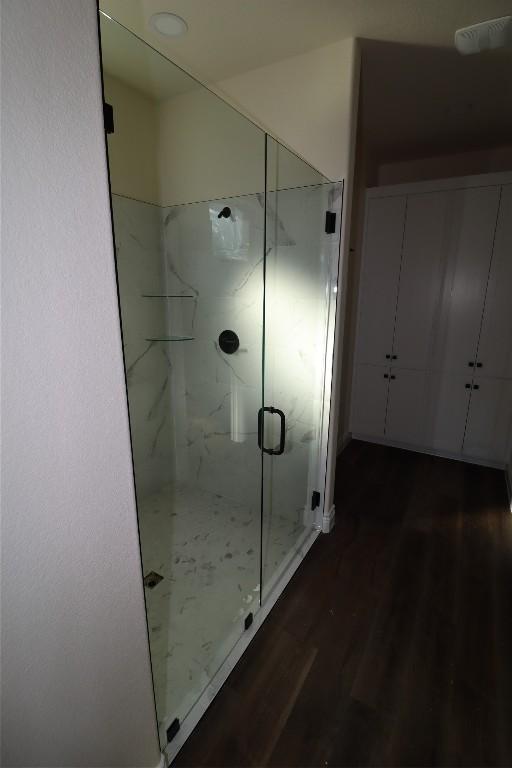 bathroom featuring wood-type flooring and a shower with door