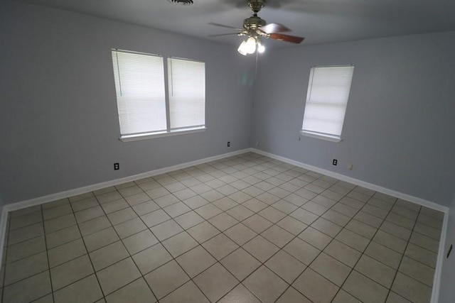 tiled spare room featuring plenty of natural light and ceiling fan