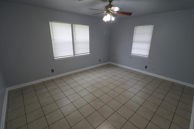 tiled empty room featuring ceiling fan and a healthy amount of sunlight