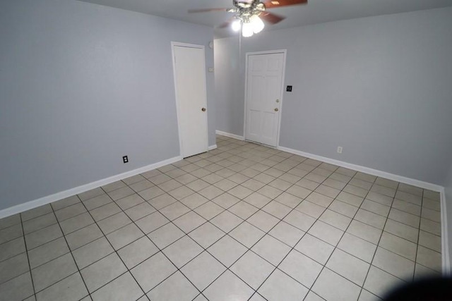 tiled spare room featuring ceiling fan