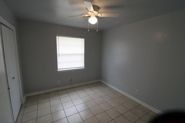 tiled empty room featuring ceiling fan