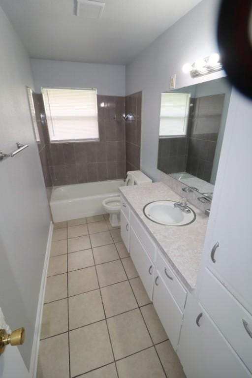 full bathroom with tile patterned flooring, vanity, toilet, and tiled shower / bath combo