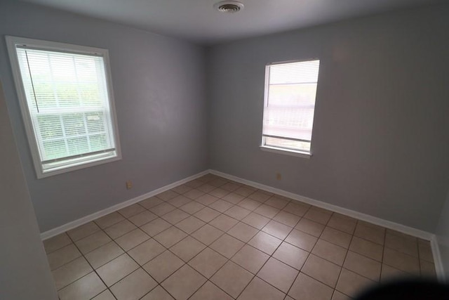 tiled empty room featuring plenty of natural light