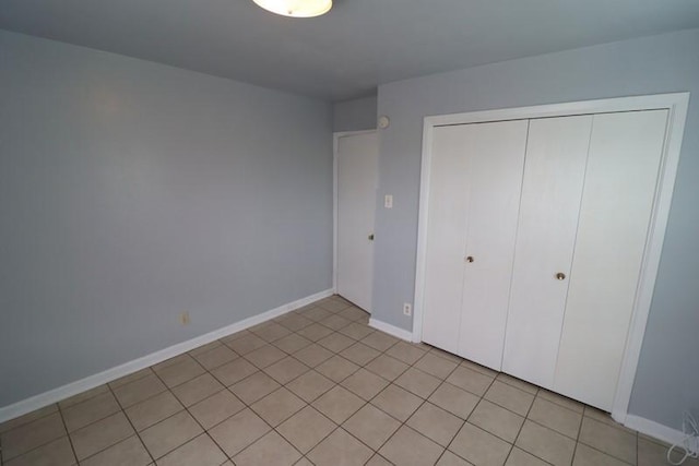 unfurnished bedroom with light tile patterned floors and a closet