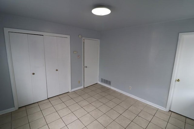 unfurnished bedroom with a closet and light tile patterned floors