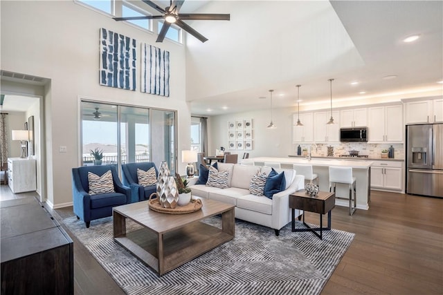 living room with dark hardwood / wood-style flooring, sink, and a high ceiling