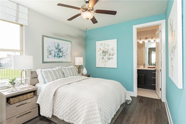 bedroom with connected bathroom, ceiling fan, dark wood-type flooring, and multiple windows