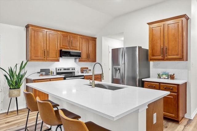 kitchen featuring ventilation hood, a center island with sink, sink, vaulted ceiling, and stainless steel appliances