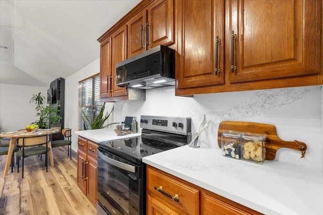 kitchen featuring light hardwood / wood-style flooring, stainless steel appliances, and lofted ceiling