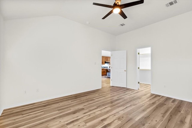 spare room featuring ceiling fan, lofted ceiling, and light hardwood / wood-style flooring