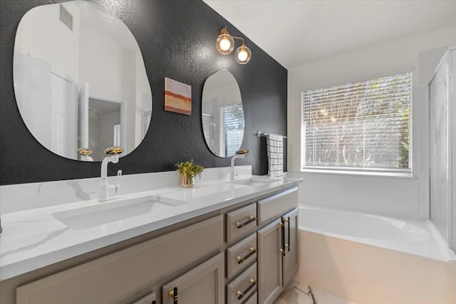 bathroom with vanity and a bath