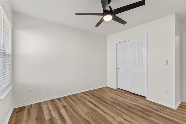 unfurnished bedroom featuring ceiling fan, a closet, and wood-type flooring