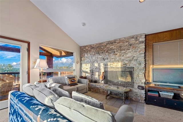 living room with a stone fireplace, light tile patterned floors, and high vaulted ceiling