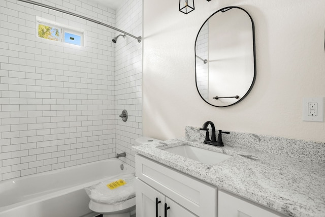 full bathroom featuring toilet, vanity, and tiled shower / bath