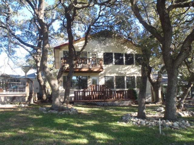 back of property featuring a yard and a deck