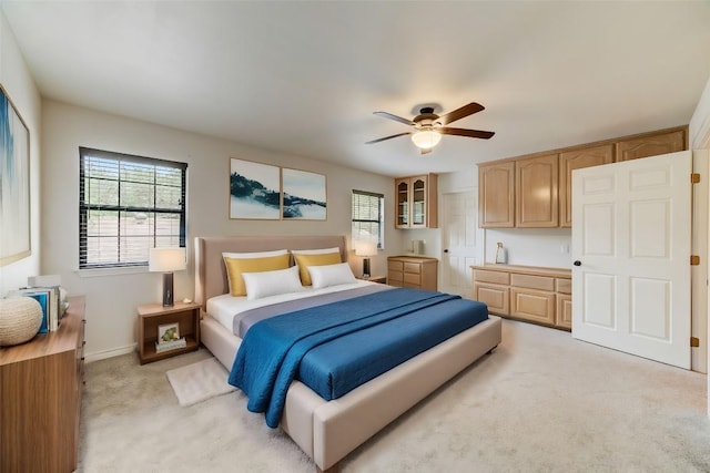 carpeted bedroom featuring multiple windows and ceiling fan