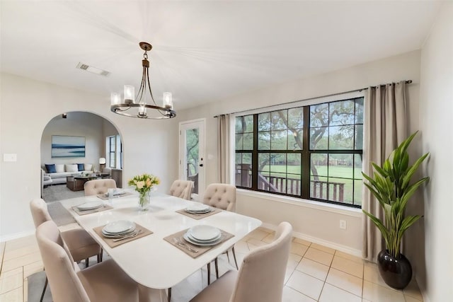 dining room featuring light tile patterned floors, plenty of natural light, and a notable chandelier