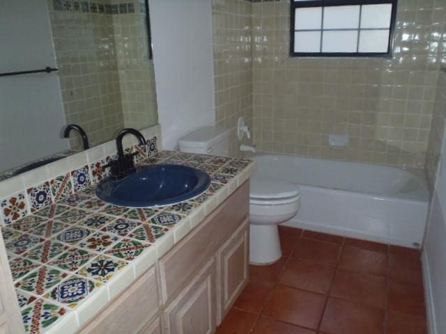 full bathroom with tile patterned flooring, vanity, toilet, and tiled shower / bath combo