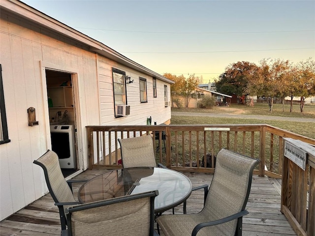 deck at dusk featuring a yard and heating unit