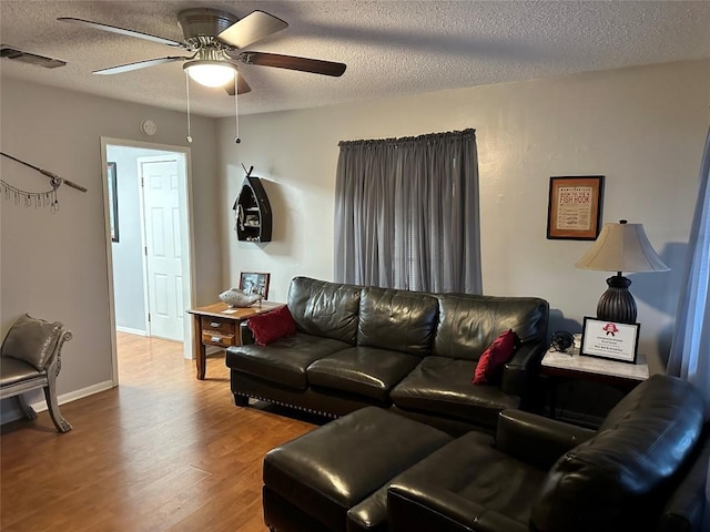 living room with ceiling fan, hardwood / wood-style floors, and a textured ceiling