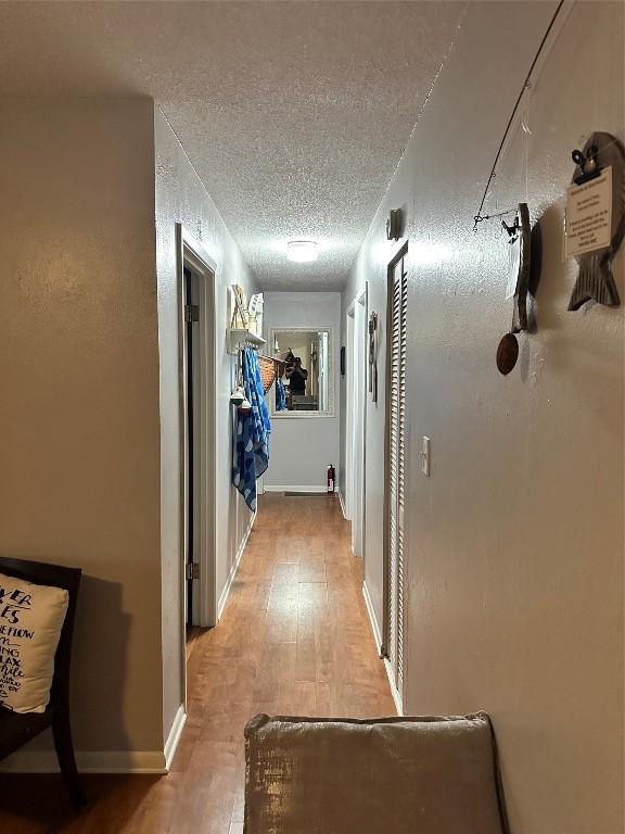 hallway featuring wood-type flooring and a textured ceiling