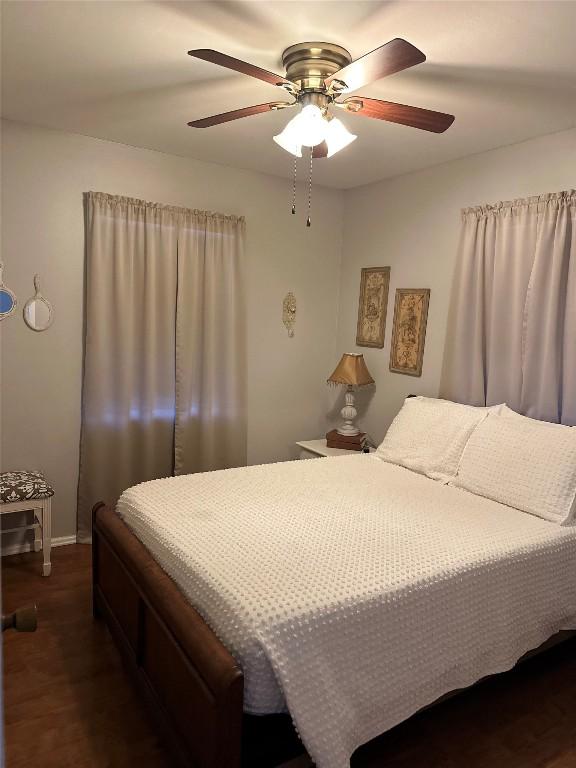 bedroom with dark hardwood / wood-style floors and ceiling fan