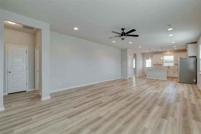 unfurnished living room with ceiling fan and light wood-type flooring