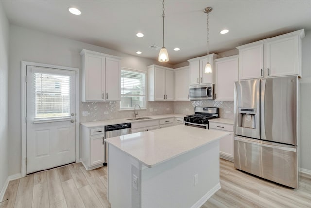 kitchen featuring white cabinetry, plenty of natural light, a kitchen island, and appliances with stainless steel finishes