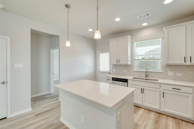 kitchen featuring white cabinets, dishwasher, light hardwood / wood-style floors, and sink