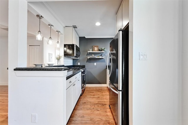 kitchen featuring backsplash, white cabinets, decorative light fixtures, light hardwood / wood-style floors, and stainless steel appliances