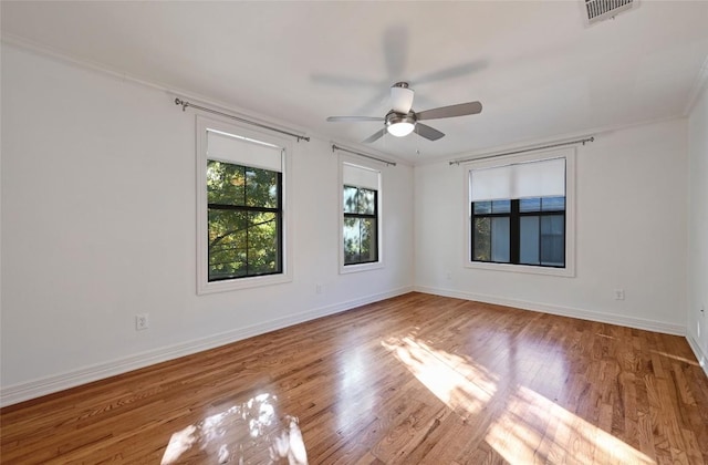 spare room with ceiling fan, ornamental molding, and light wood-type flooring