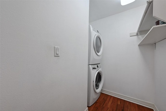 laundry area featuring dark hardwood / wood-style flooring and stacked washer and dryer