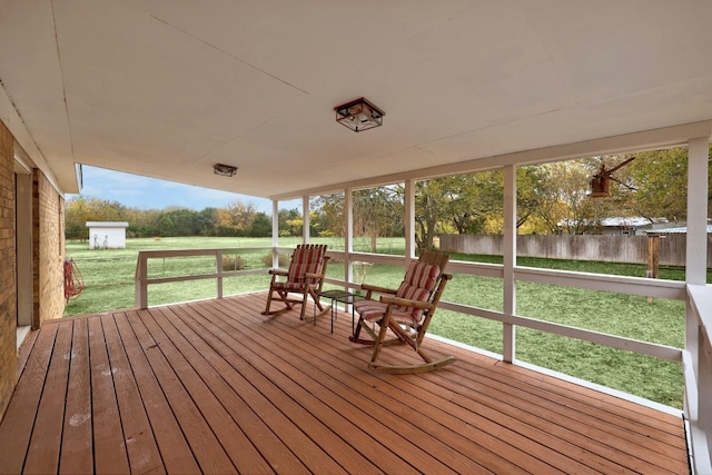 wooden terrace with a lawn and a shed