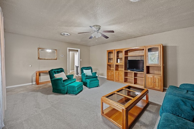 living room featuring ceiling fan, carpet, and a textured ceiling