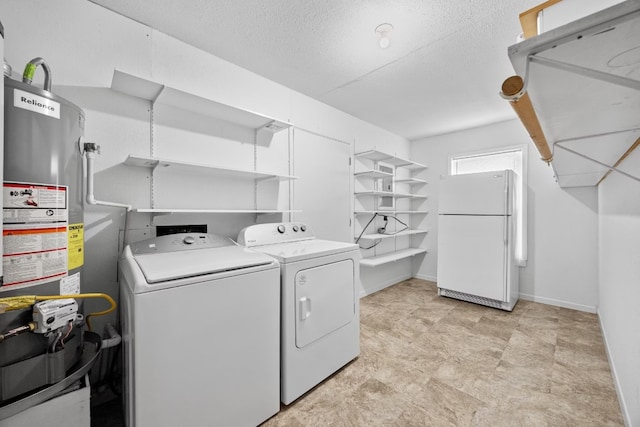 laundry room with a textured ceiling, washer and clothes dryer, and water heater