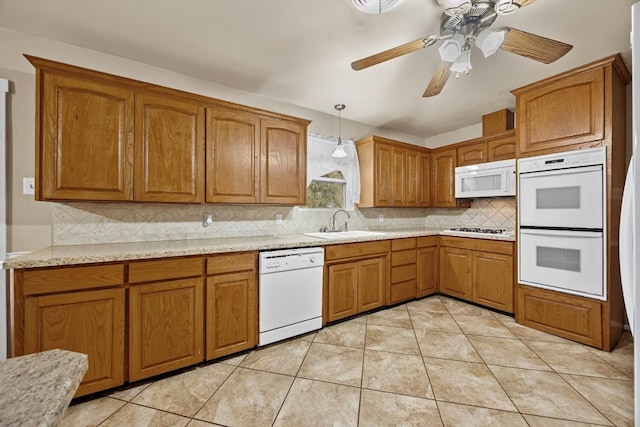 kitchen with tasteful backsplash, white appliances, ceiling fan, sink, and pendant lighting