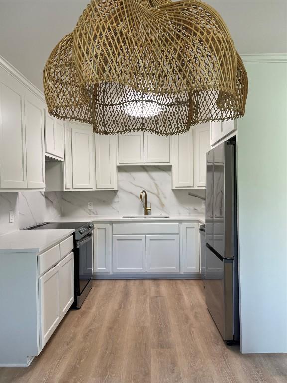 kitchen featuring appliances with stainless steel finishes, white cabinetry, and sink