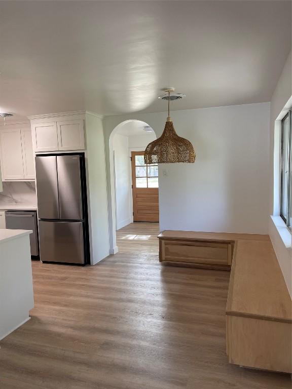 unfurnished dining area featuring light wood-type flooring