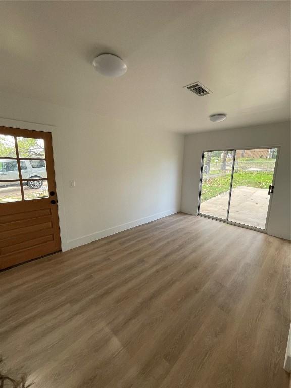 unfurnished room with hardwood / wood-style flooring and a healthy amount of sunlight