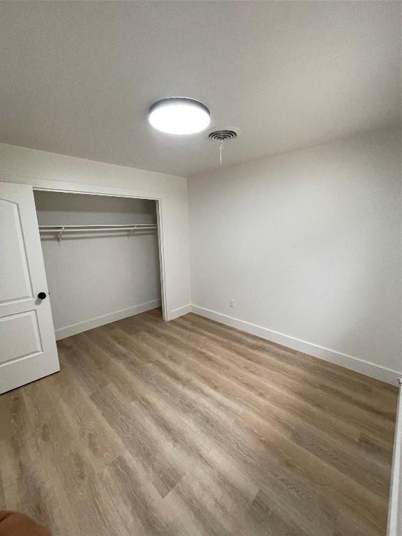 unfurnished bedroom featuring hardwood / wood-style flooring and a closet