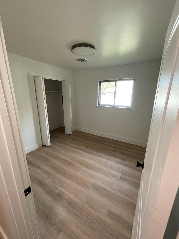 unfurnished bedroom featuring a closet and light hardwood / wood-style floors