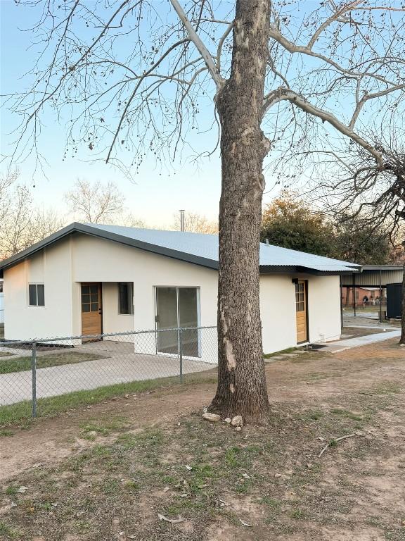 back of house with fence and stucco siding