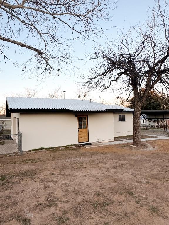 rear view of house featuring stucco siding